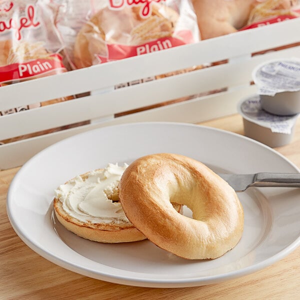 An unwrapped Burry plain bagel with cream cheese on a plate.