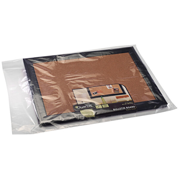 A close up of a clear Lavex poly bag holding a brown and orange food package on a table.