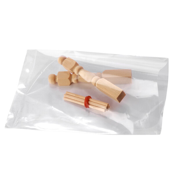A few wooden objects in a clear plastic Lavex poly bag.