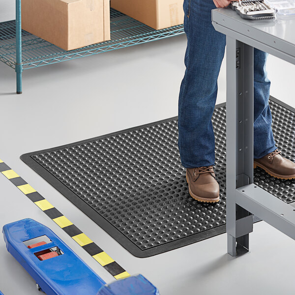 A man standing on a black Lavex BubbleFlex anti-fatigue mat.