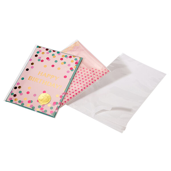 A clear Lavex polypropylene bag holding pink cards with gold polka dots.