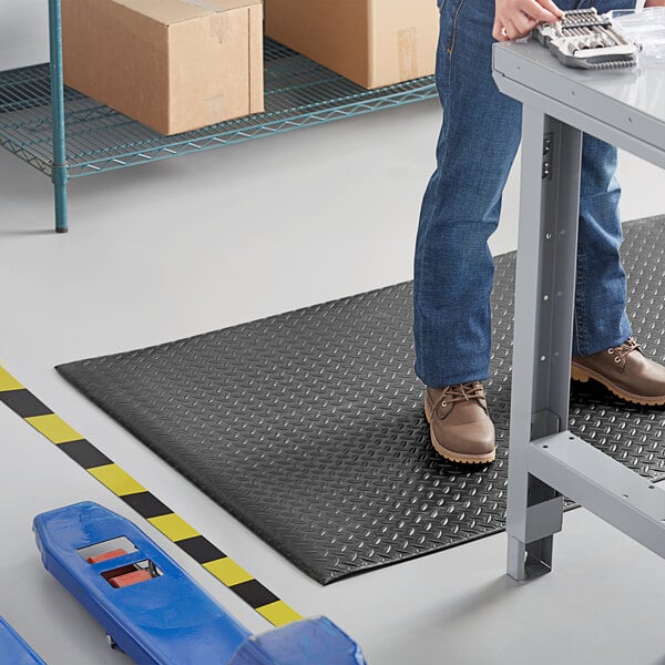 A man standing on a black Lavex Diamond Deluxe anti-fatigue mat.