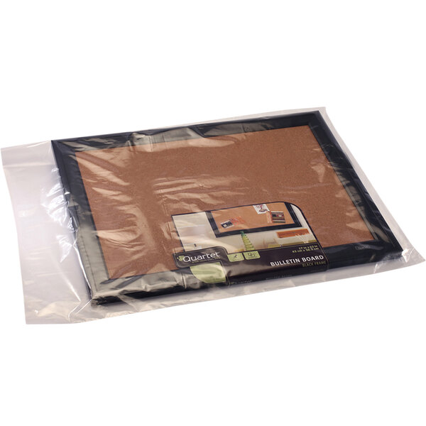 A Lavex clear plastic poly bag holding a cork board.