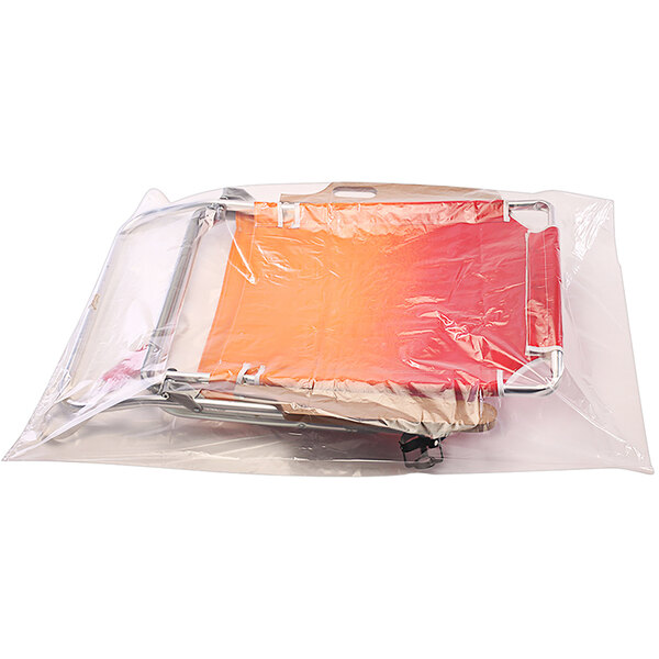 A clear plastic bag on a roll with a red and orange chair inside.