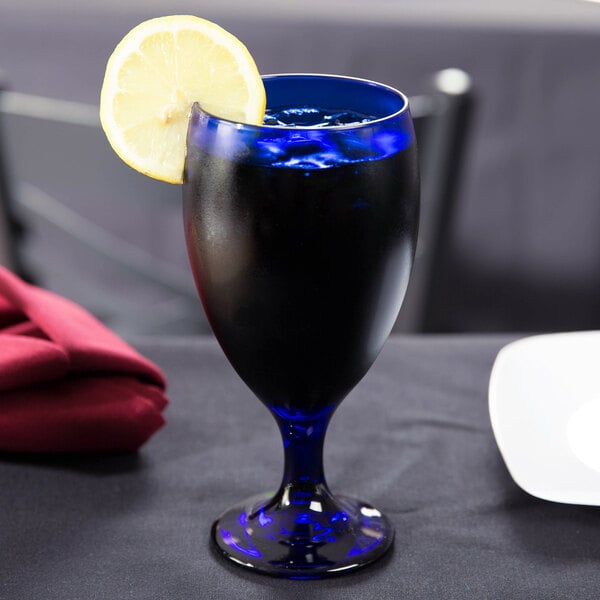 A Libbey cobalt blue tall iced tea glass with a drink and a lemon slice.