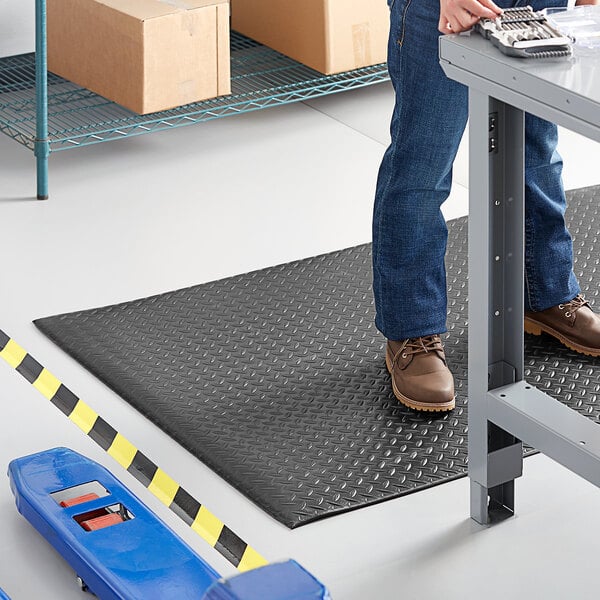 A man standing on a Lavex Diamond Deluxe black anti-fatigue mat.