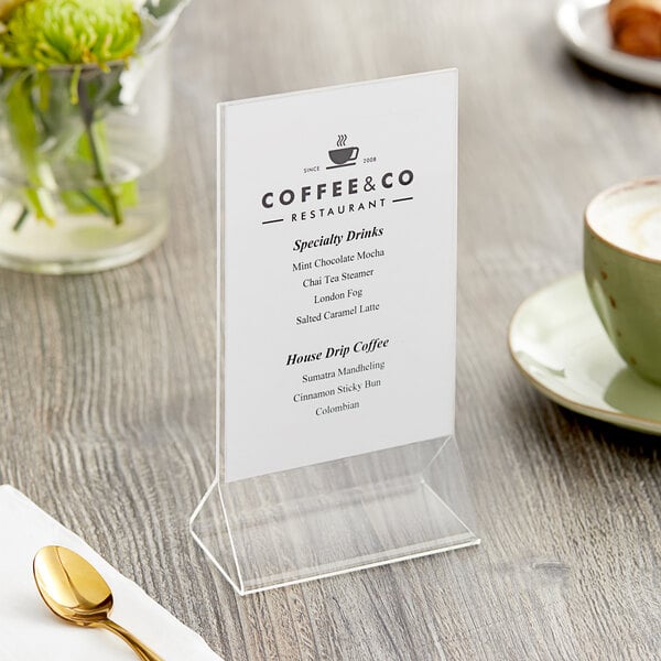 A Choice 4" x 6" acrylic tabletop displayette holding a menu on a table.