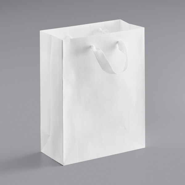 A white paper bag with white ribbon handles.