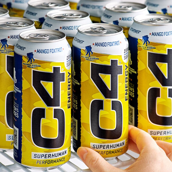 A person holding a yellow and black C4 Energy drink can.