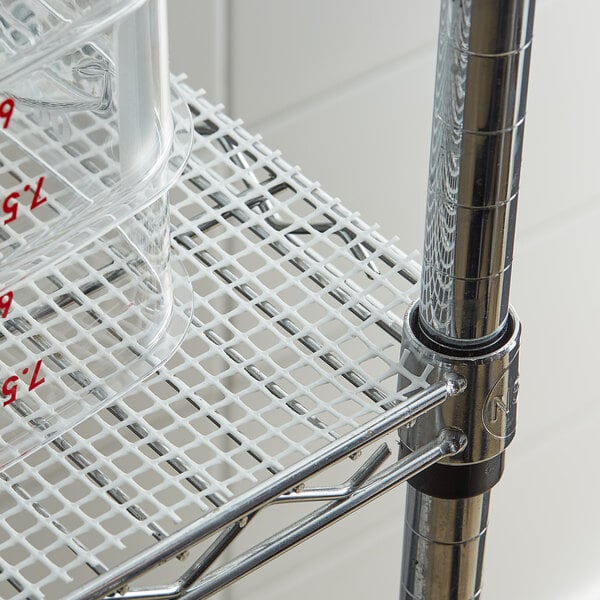 A metal shelf with a plastic container on white plastic mesh shelf liner.