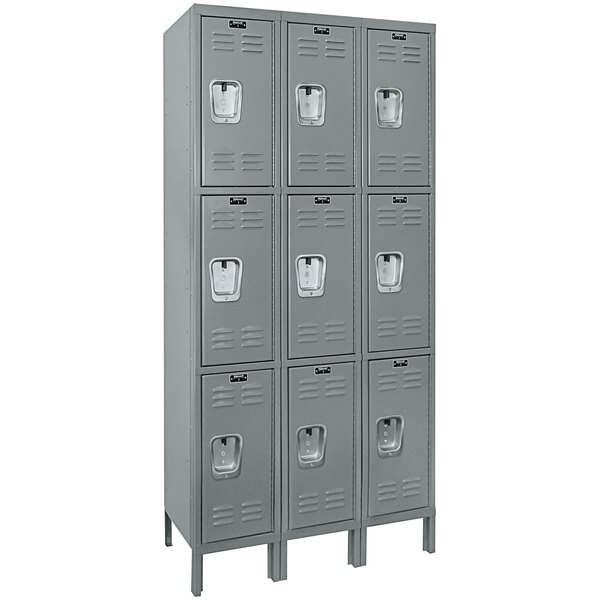 A row of Hallowell grey triple lockers with recessed white handles.