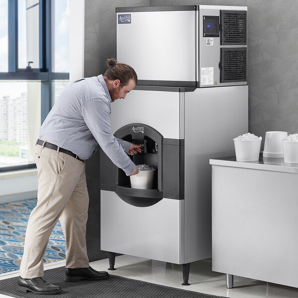 A man putting ice in a container from an Avantco ice machine.