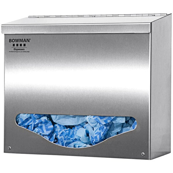 A stainless steel BOWMAN single bulk dispenser on a wall filled with blue gloves.
