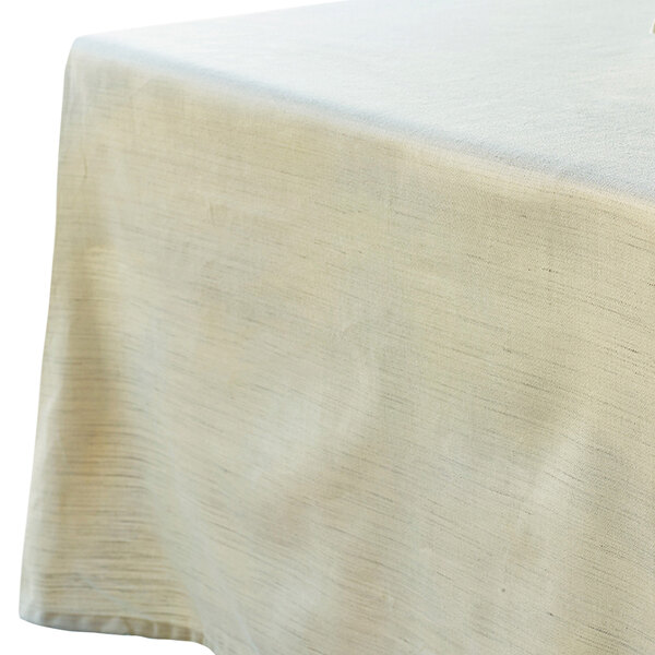 A white Garnier-Thiebaut tablecloth on a table.