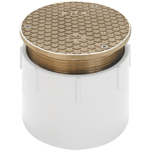 A white plastic pipe with a round lid and a gold square pattern.