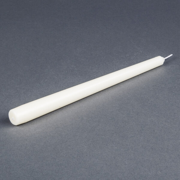 A 12 pack of Will & Baumer ivory taper candles on a gray surface.