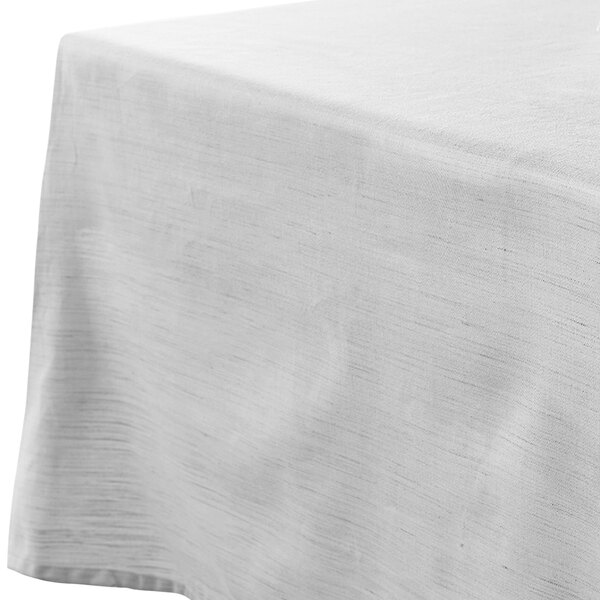 A white Garnier-Thiebaut tablecloth on a table.