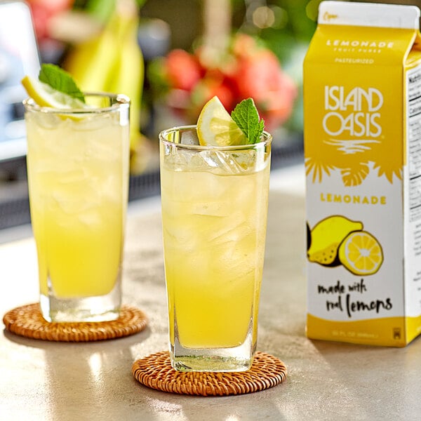 A glass of Island Oasis lemonade with ice and lemons.