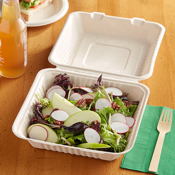 A salad in an EcoChoice bagasse take-out container on a table.