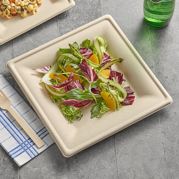 A plate of salad on a table served on an EcoChoice natural bagasse square plate with a wooden fork.