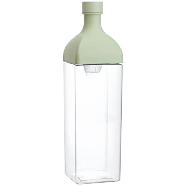 A clear plastic container with a green lid containing a Hario Ka-Ku Smokey Green Tritan plastic tea infuser.