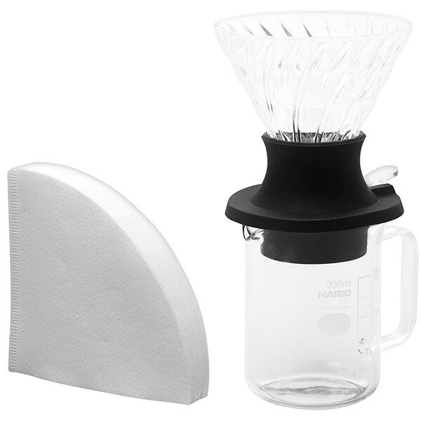 A Hario V60 glass coffee maker with a black handle and a glass server.