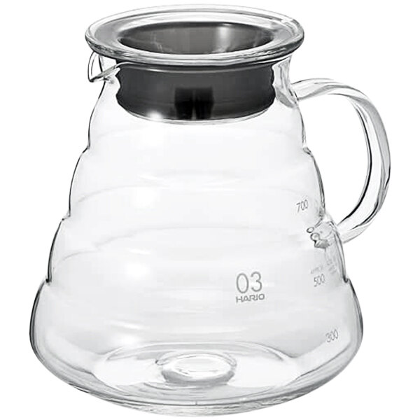 A clear glass Hario coffee server with a black handle.