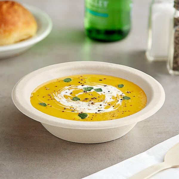 A bowl of EcoChoice bagasse blend soup with a white and green swirl on top.