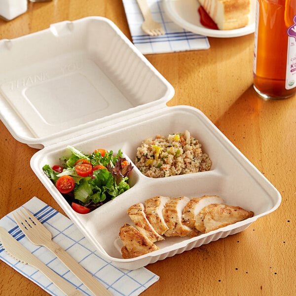 A EcoChoice bagasse take-out container with chicken and salad on a plate.