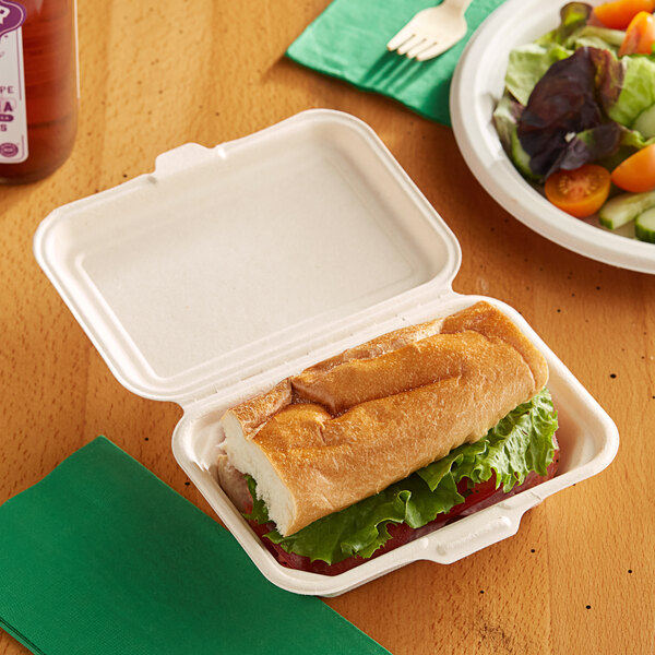 A sandwich in an EcoChoice Natural Bagasse take-out container on a table.