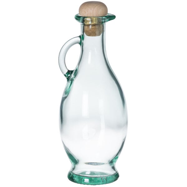 A Tablecraft clear glass olive oil bottle with a cork stopper and a wooden lid.