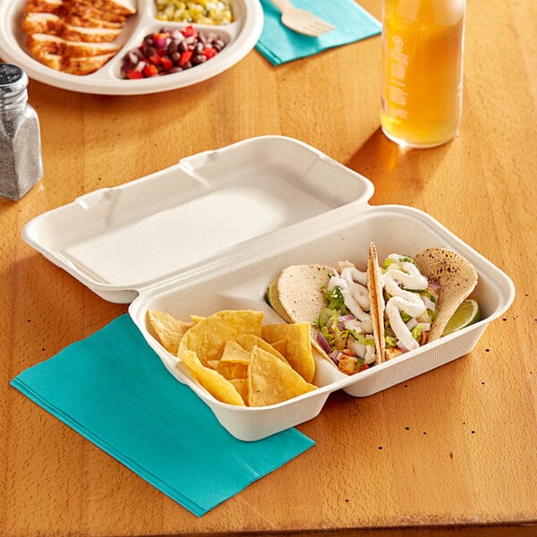 A white EcoChoice bagasse take-out container filled with food on a table.