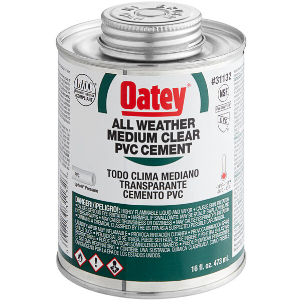 A white can of Oatey clear PVC all weather cement with a green label.