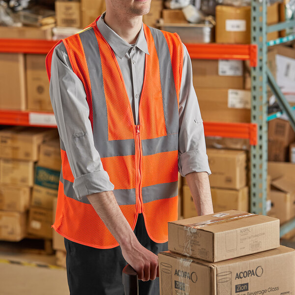 A man in a Lavex orange safety vest holding a brown box.