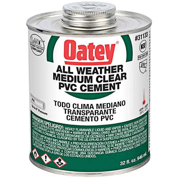 A 32 oz. white and green Oatey clear PVC cement can with a white label.