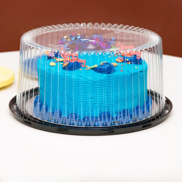 A blue cake in a D&W Fine Pack plastic container with a clear plastic cover.