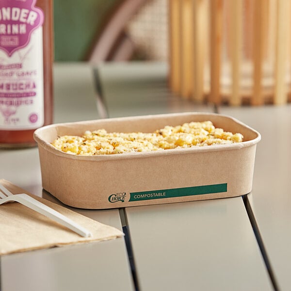 A rectangular EcoChoice paper take-out container with food in it on a table.