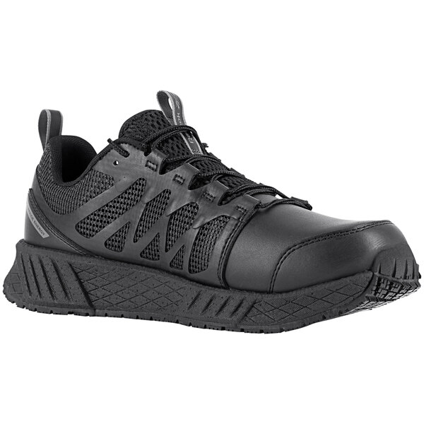 A pair of Reebok Work black athletic shoes with laces and a composite toe on a table.