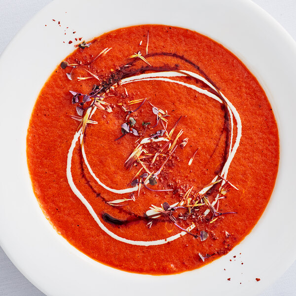 A white plate with roasted red bell peppers in a bowl.