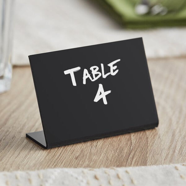 A black Choice tabletop chalkboard sign with white text on a table.