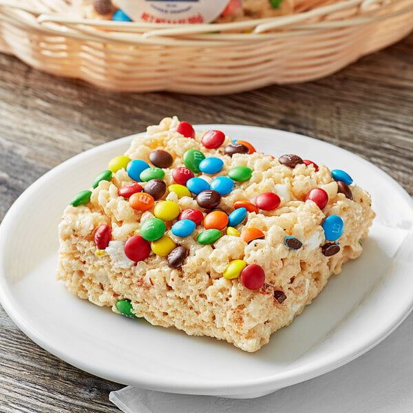 A square white plate with Best Maid Marshmallow Crispy Bars with M&M's on it.