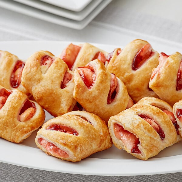 A plate of Brill Strawberry Cream Cheese Sugar Mini Strudels with jam on top.