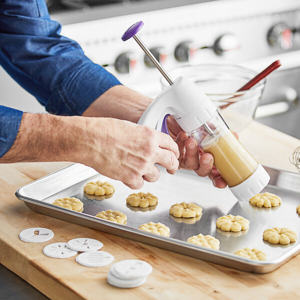 A person using a Wilton Simple Cookie Press to make cookies.