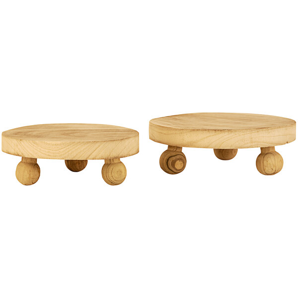 A pair of wooden round display stands with feet.