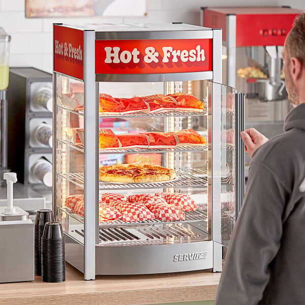 A man looking at hot and fresh food in a ServIt countertop display case.