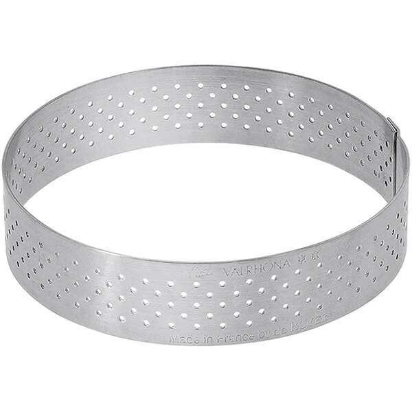 A silver stainless steel circular tart ring with holes.