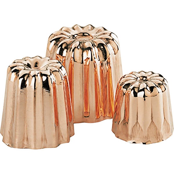 A group of shiny copper de Buyer Cannele molds.