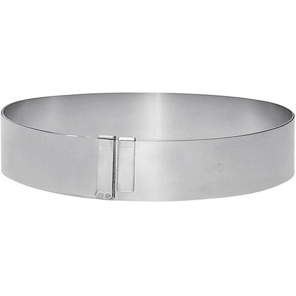 A silver circular stainless steel expandable pastry frame with a clip.