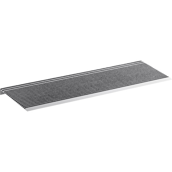 A black mat with black grit strips on a metal shelf.
