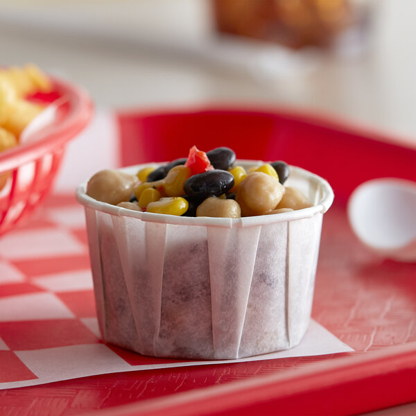 A red tray with a Genpak Harvest paper souffle cup of food.